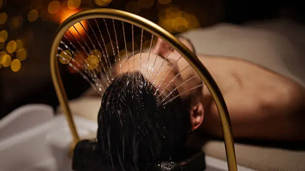 Homme détendu sous l'arche à eau du Head Spa